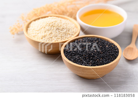 Black and white sesame seeds and oil (Cold pressed) in bowl on white table, Food ingredient 118183058