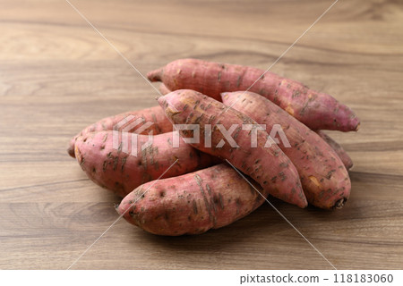 Raw organic Japanese sweet potatoes on wooden background 118183060