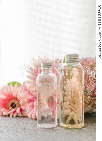 Pink flowers and plastic cosmetic bottles large and small 118183410