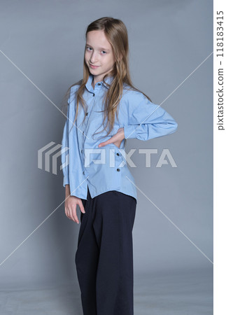 Youthful charm meets stylish comfort in a girl's poised posture. Suitable for schoolwear and leisure fashion promotions. 118183415