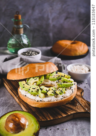 Delicious ricotta and avocado bagel on a breakfast board vertical view Delicious ricotta and avocado bagel on a breakfast board vertical view 118183647