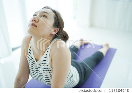 Asian woman practices yoga exercise at home. Asian woman practices yoga exercise at home. 118184948
