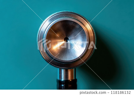 A striking stethoscope stands alone, its polished surface glimmering against a bright teal backdrop, symbolizing the essence of healthcare and the importance of sound in patient diagnosis. A striking stethoscope stands alone, its polished surface glimmering against a bright teal backdrop, symbolizing the essence of healthcare and the importance of sound in patient diagnosis. 118186132