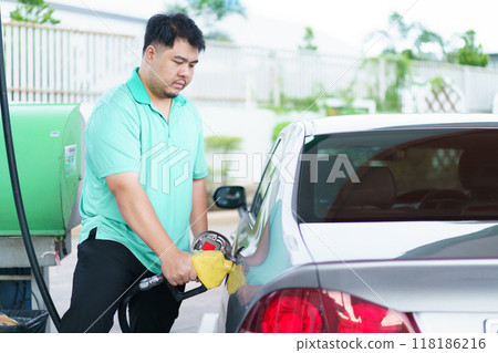 Asian man is refuels his car a gas. 118186216