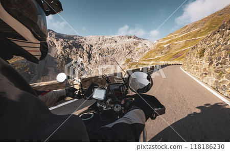 Detail of motorcycle handlebars. View from driver perspective, beautiful Alpine landscape in sunset light. Detail of motorcycle handlebars. View from driver perspective, beautiful Alpine landscape in sunset light. 118186230