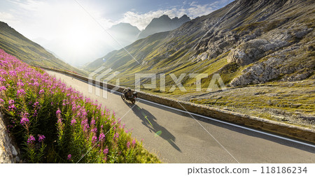 Motorbiker riding in Italian Dolomites, dramatic sky. Motorbiker riding in Italian Dolomites, dramatic sky. 118186234