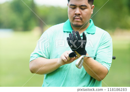 Male golfer is wearing a glove. 118186283