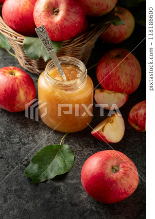 Apple jam and fresh apples on a black stone table. Apple jam and fresh apples on a black stone table. 118186600