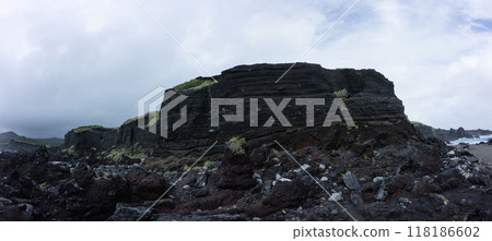 Black cliffs made of volcanic ash, volcanic ash layers on Izu Oshima, and huge rocks that rise from the coastline 118186602