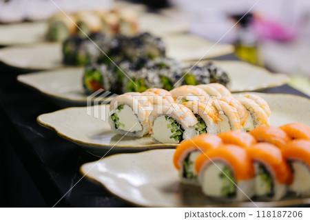 Assorted sushi rolls on plates in a restaurant setting, highlighting a variety of fresh ingredients Assorted sushi rolls on plates in a restaurant setting, highlighting a variety of fresh ingredients 118187206
