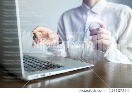 A man is using a laptop with a graph on the screen 118187234