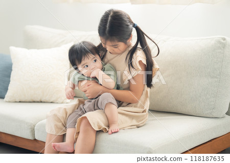 Older sister comforting her younger brother 118187635