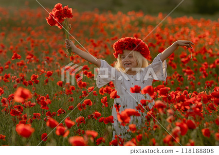 A young girl is standing in a field of red poppies, holding a bouquet of flowers. She is smiling and she is enjoying the beautiful scenery. Concept of joy and happiness 118188808