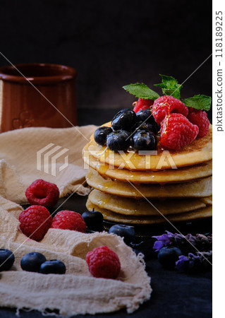 pancakes with berries and honey on dark background 118189225