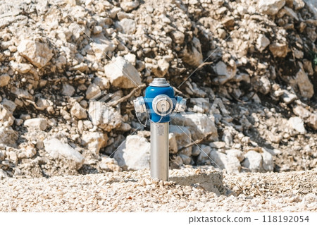 Blue fire hydrant against rocky terrain 118192054