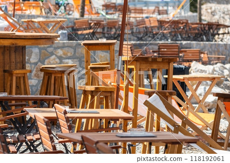 Outdoor wooden tables and chairs at cafe 118192061