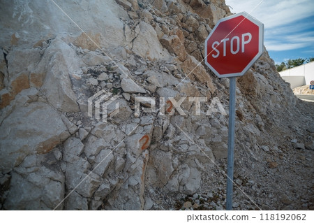 Stop sign next to rocky mountain slope Stop sign next to rocky mountain slope 118192062