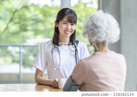 Nurse measuring blood pressure of a senior woman Nurse measuring blood pressure of a senior woman 118192114