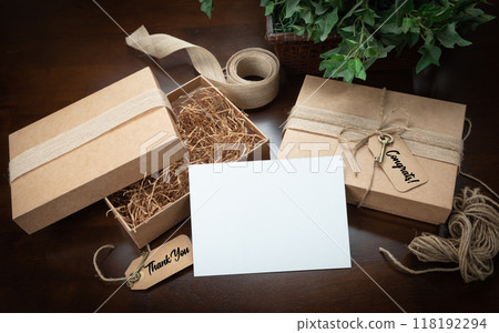 Gift Packaging Boxes Mock Up with Jute String, Thank You and Congratulations Card and Tags with Small Key on Wood Surface. 118192294