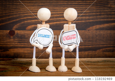 Urologist and Gynecologist. Two speech bubbles and miniature people on a wooden texture background 118192469