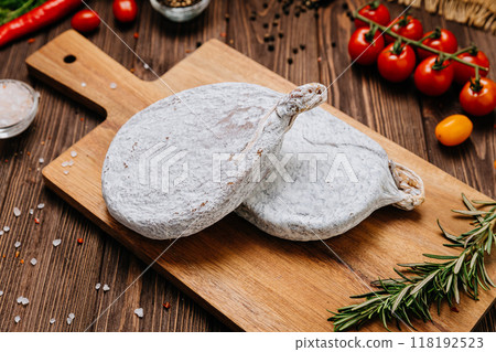 Dry-cured salami on board, ideal for rustic charcuterie presentations and gourmet food styling 118192523