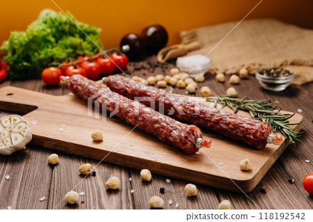 Smoked sausages on a rustic wooden board, perfect for culinary presentations and food styling 118192542