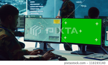 Private monitors national guard activity with military CCTV satellite system, working with a greenscreen display on pc in command center. IT reconnaissance operator tracking ships. Camera A. Private monitors national guard activity with military CCTV satellite system, working with a greenscreen display on pc in command center. IT reconnaissance operator tracking ships. Camera A. 118193140