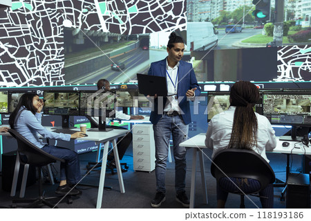 Indian supervisor handles express delivery orders through city traffic, working with his team to provide alternative routes via satellite navigation and CCTV footage. Gps tracking system. Indian supervisor handles express delivery orders through city traffic, working with his team to provide alternative routes via satellite navigation and CCTV footage. Gps tracking system. 118193186