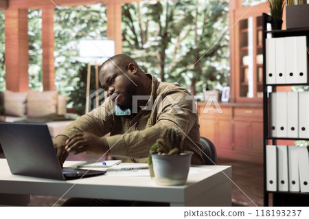 Financial consultant answering a phone call from a stakeholder at home, ensuring expansion project progress to increase the funding. Confident entrepreneur shares the current situation. 118193237