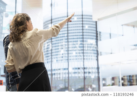 Clients and realtor on an office tour evaluating modern workspace design and discussing investment strategies and leasing options. Planning to invest funds in property, office hunt. 118193246