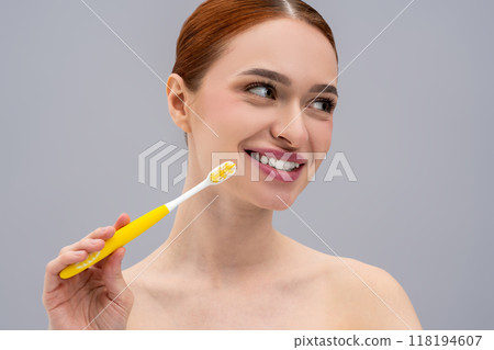 Beautiful young red-haired woman brushing her teeth with toothbrush Beautiful young red-haired woman brushing her teeth with toothbrush 118194607