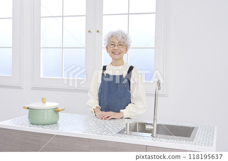 Portrait of an elderly woman standing in the kitchen 118195637