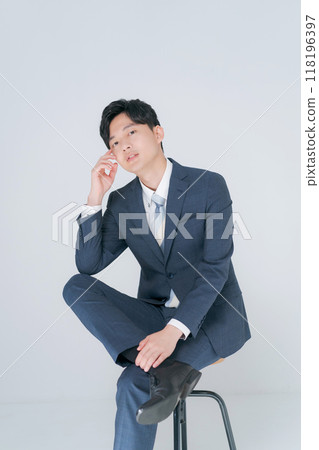 Man in suit sitting on chair Man in suit sitting on chair 118196397