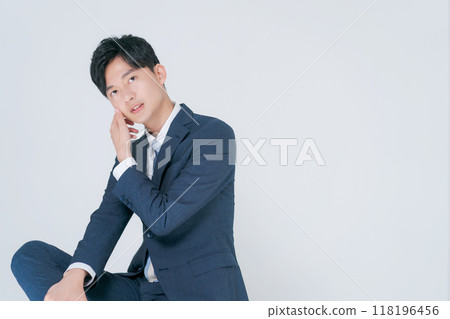 Man in suit sitting on chair 118196456