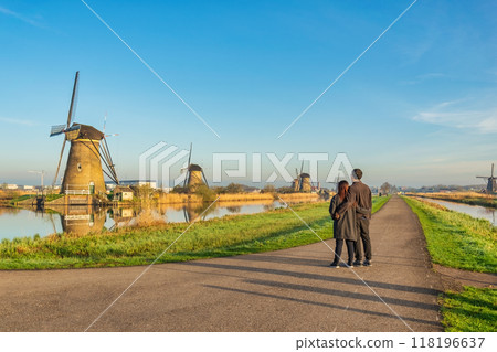 Dutch Windmill landscape at Kinderdijk Village Netherlands with love couple walking Dutch Windmill landscape at Kinderdijk Village Netherlands with love couple walking 118196637