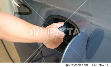 Man charging his electric car. Man charging his electric car. 118196761