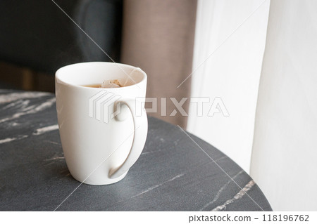 Cup of tea next to windows with white curtains. Cup of tea next to windows with white curtains. 118196762