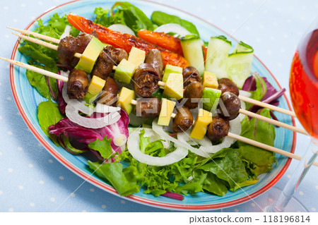 Fried shish kebab from chicken hearts served with avocado and fresh lettuce 118196814