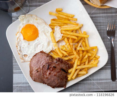 Picture of fried pork with fried eggs and french fries at plate Picture of fried pork with fried eggs and french fries at plate 118196826
