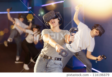 Excited girl in business suit having fun with friends in virtual reality room 118196879