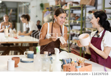 Girls processing clay bowls in carpentry workshop 118197016