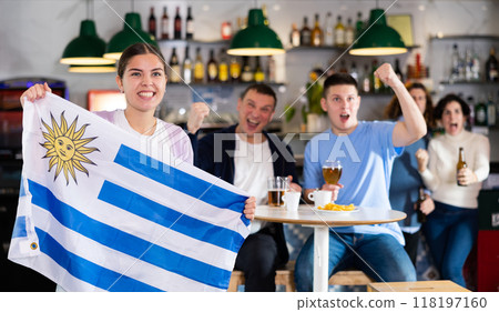 Fans with the flag of Uruguay celebrate the victory of their favorite team in beer bar 118197160