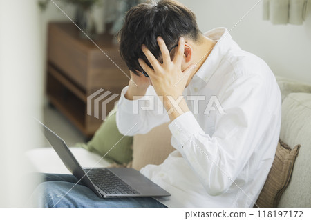 一個人在客廳裡使用個人電腦 118197172