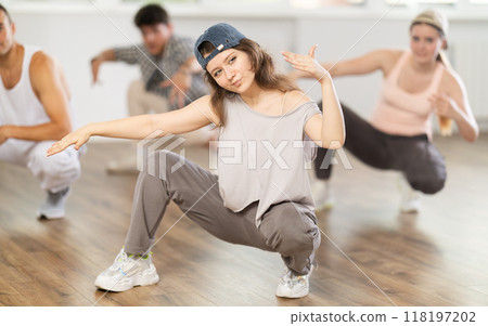 Teacher and her students squatting down and perform hip hop dance 118197202