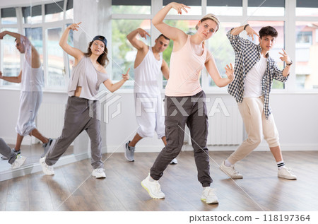 Active group sporty people practicing hip-hop dance in training hall during dancing classes 118197364