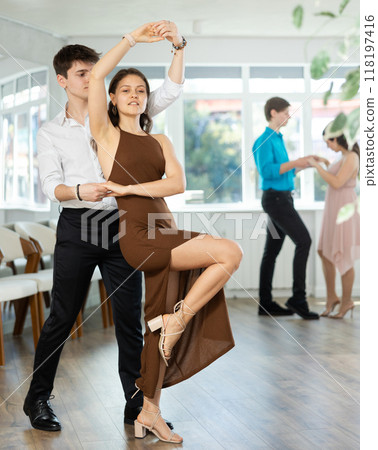 Young couples learning to dance latin american dances in dance studio Young couples learning to dance latin american dances in dance studio 118197416