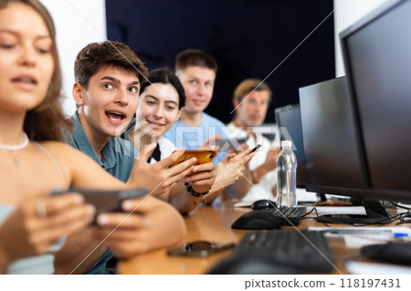 Excited young developer using mobile phone at IT startup presentation 118197431