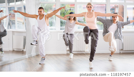 Young girl standing performs basic hip hop movements in front of group of students 118197457