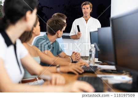 Instructor conducting software development courses to young guys and girls 118197509