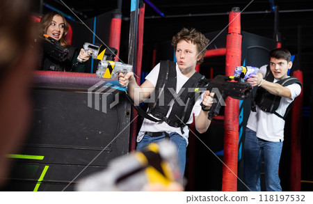 Portrait of excited people playing enthusiastically laser tag game two teams opposite each other in room 118197532